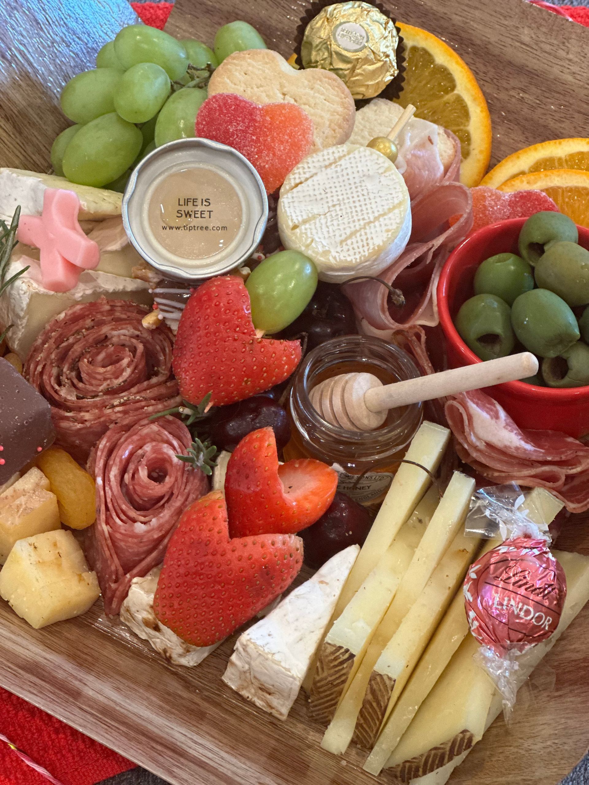 a tray of charcuterie board food with a lid that says life is sweet