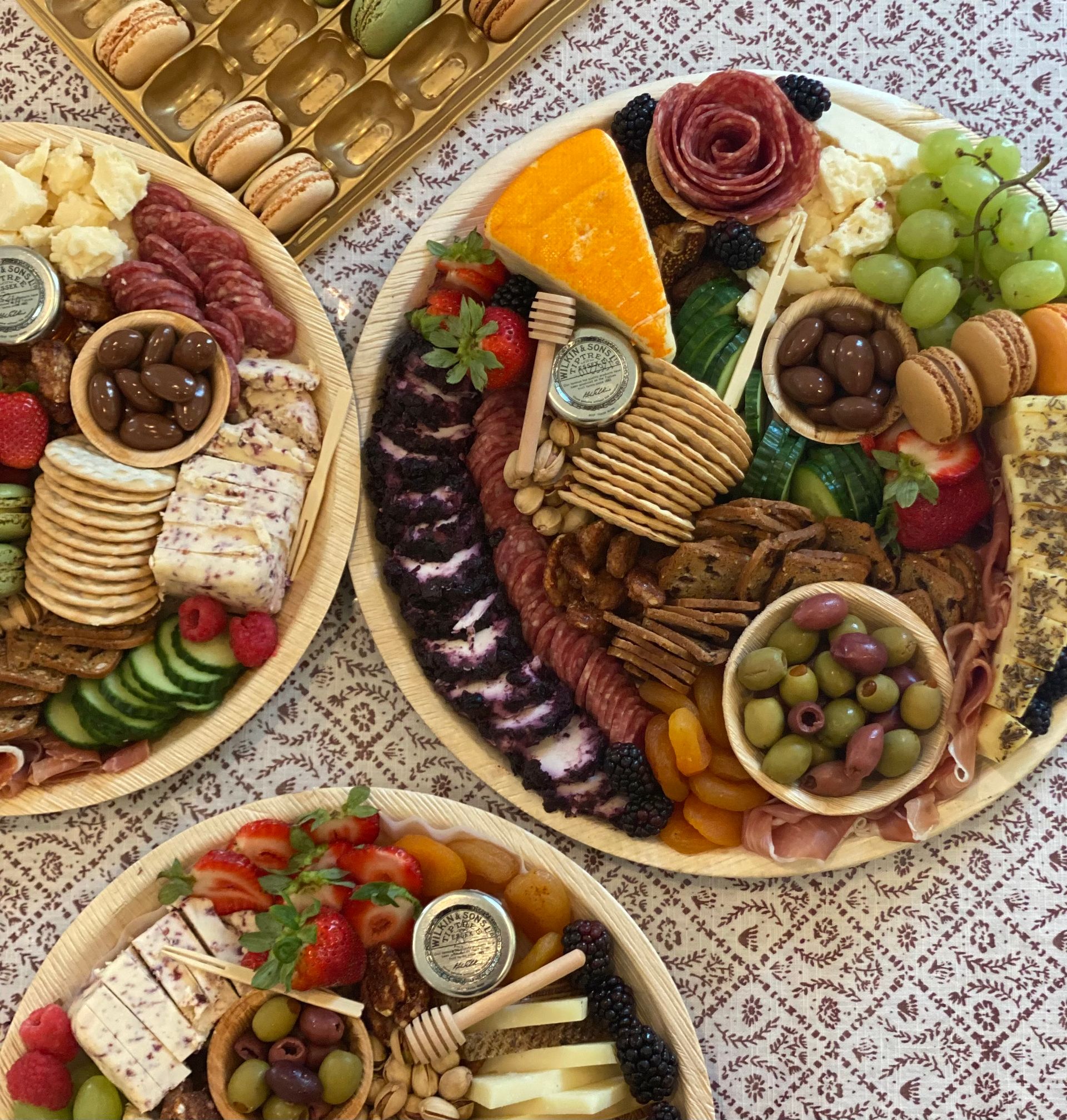 three plates of food on a table one of which has a jar of honey on it