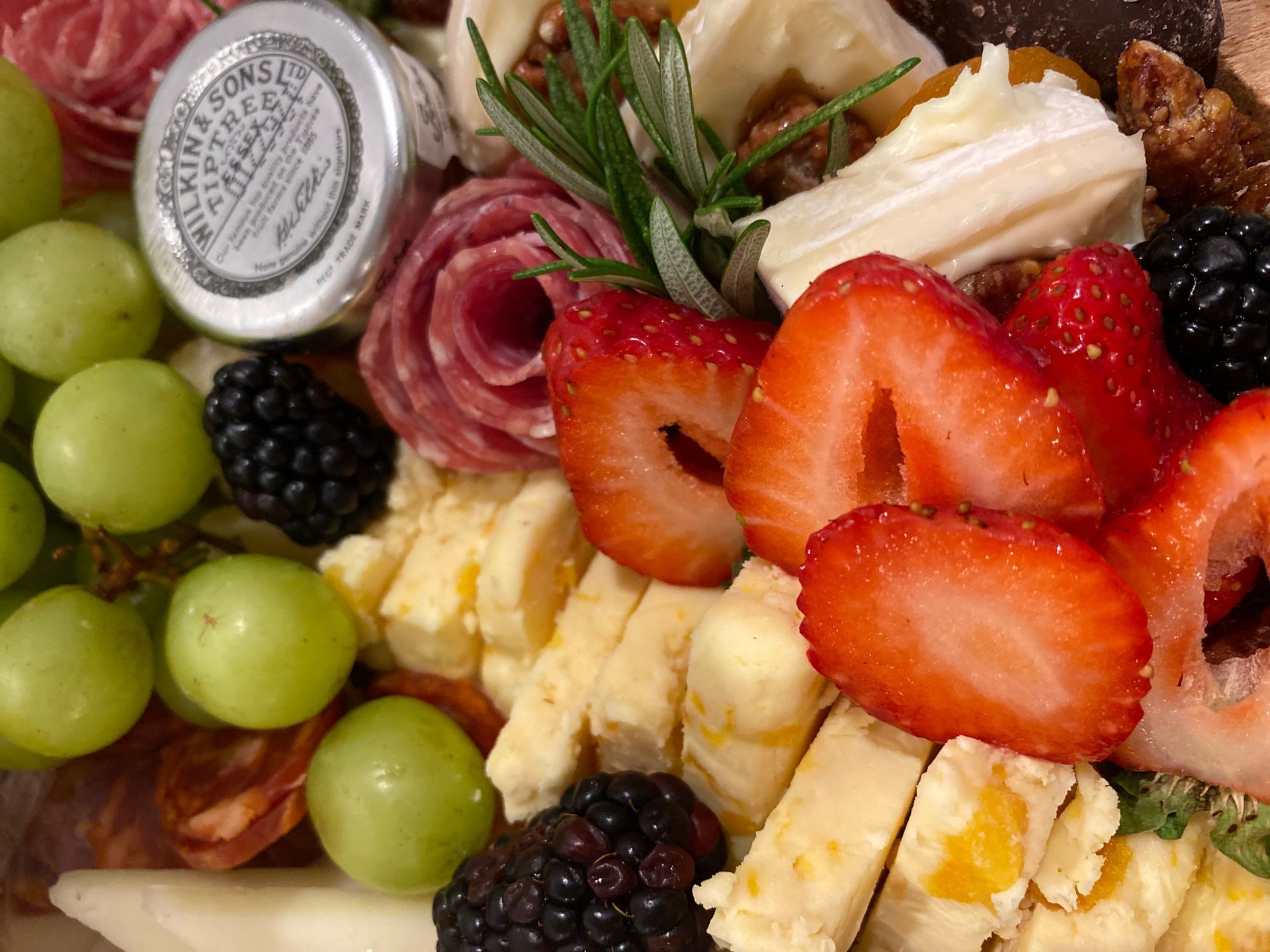 a close up of a plate of food with strawberries and grapes