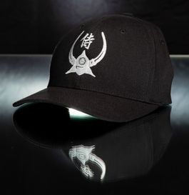 Black baseball cap with white samurai helmet crest and Japanese symbol.