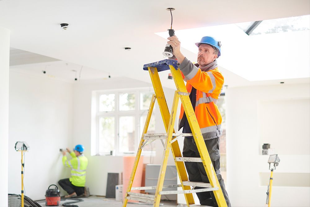 A man is working on a generator outside of a house.