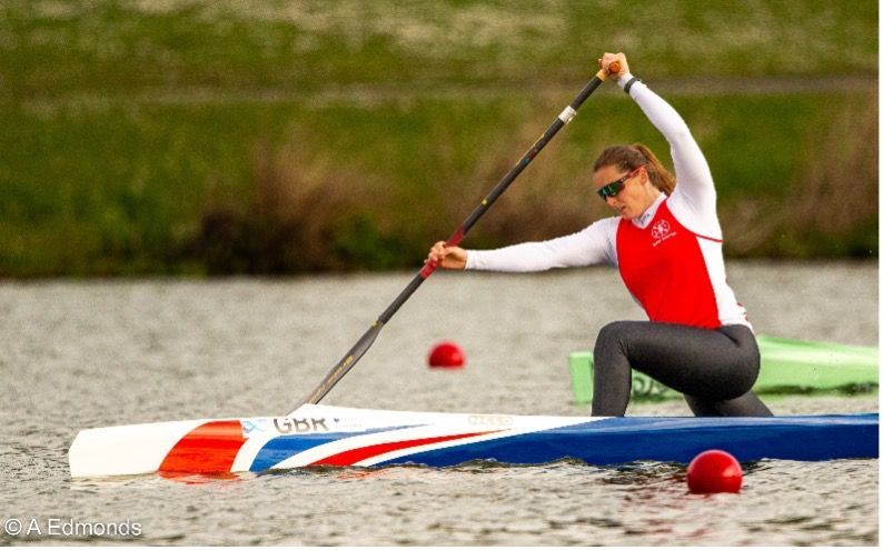 Paddle Northern Ireland | A woman is kneeling on a kayak in the water holding a paddle