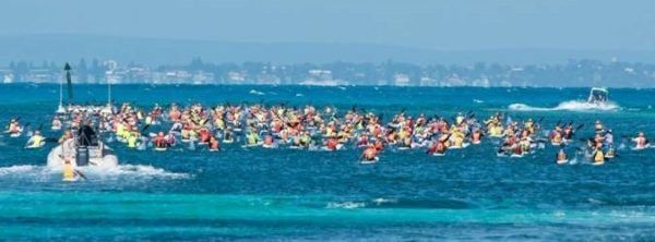 A large group of people are swimming in the ocean.