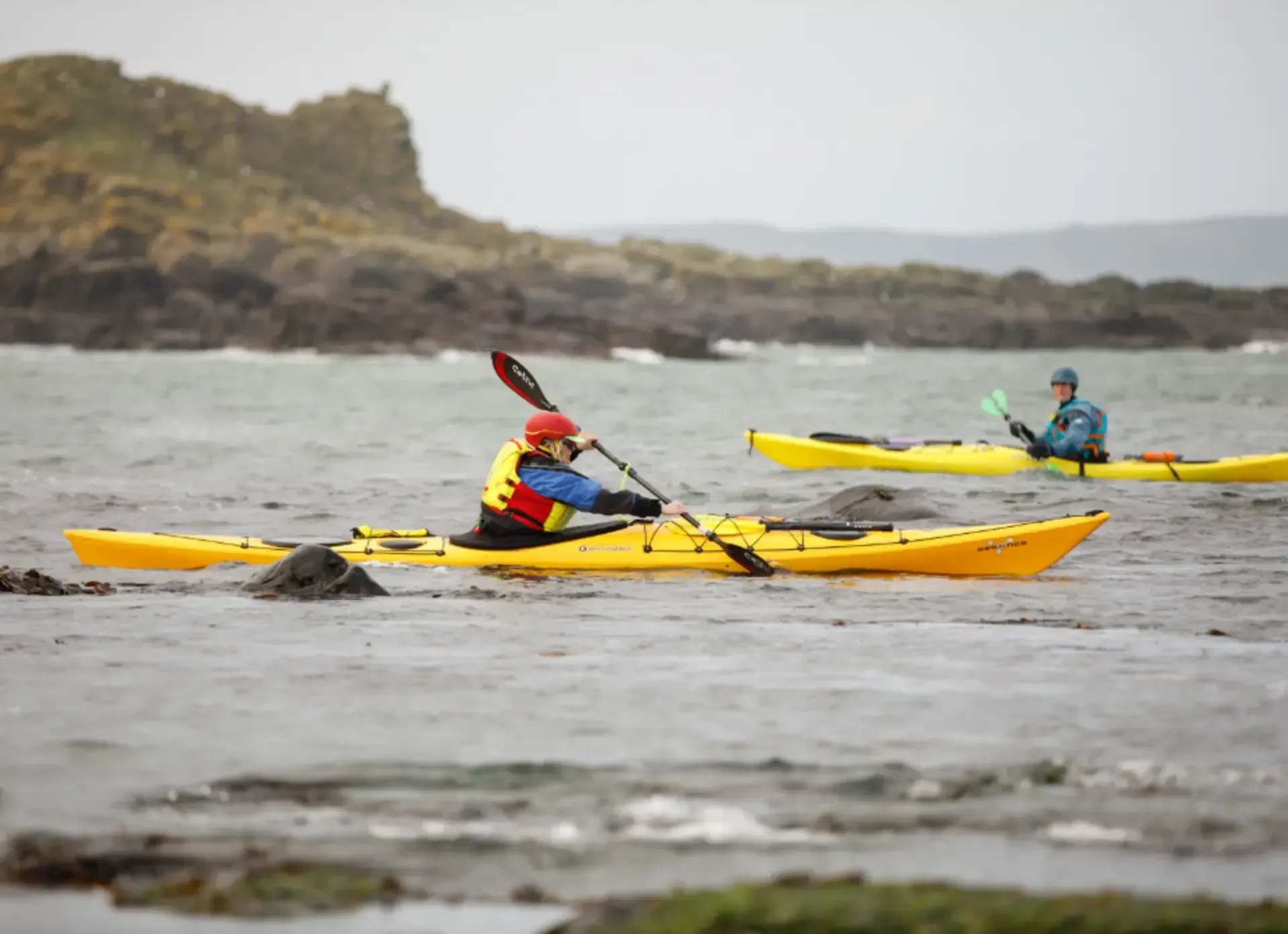 Paddler Northern Ireland | A man in a red vest is paddling a kayak on a lake