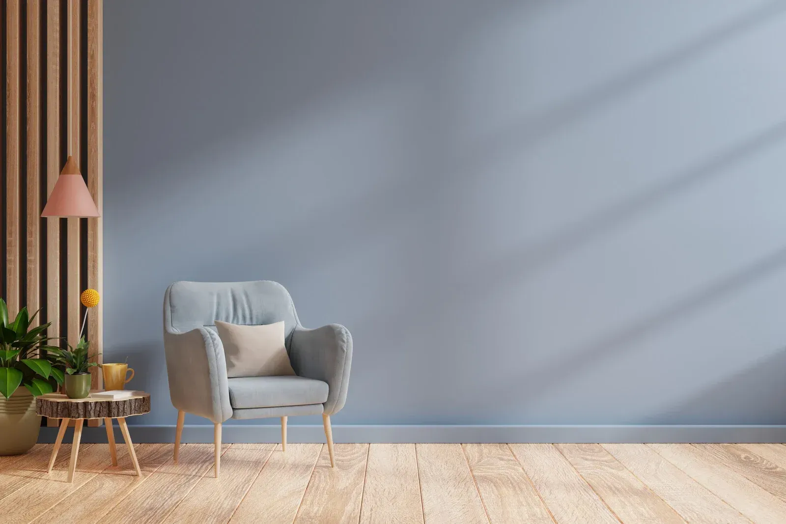 A living room with a chair , table , lamp and blue wall.