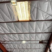 The ceiling of a building with a light hanging from it.