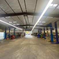 A large warehouse with a lot of lifts in it.