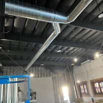 A large room with a lot of pipes hanging from the ceiling.