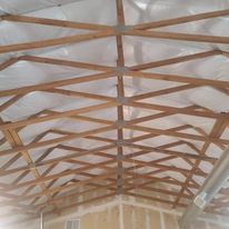 The ceiling of a building is covered in plastic and wooden beams.
