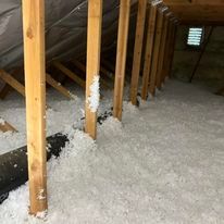There is a lot of insulation in the attic of a house.