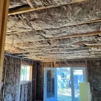 A room with a sliding glass door and a lot of insulation on the ceiling.