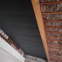 A close up of a ceiling with bricks and wooden beams.