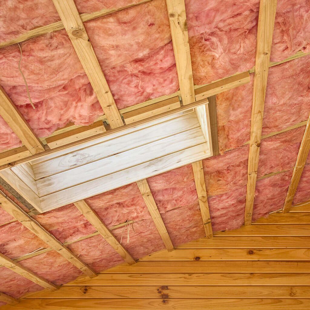 A wooden ceiling with pink insulation and a skylight.