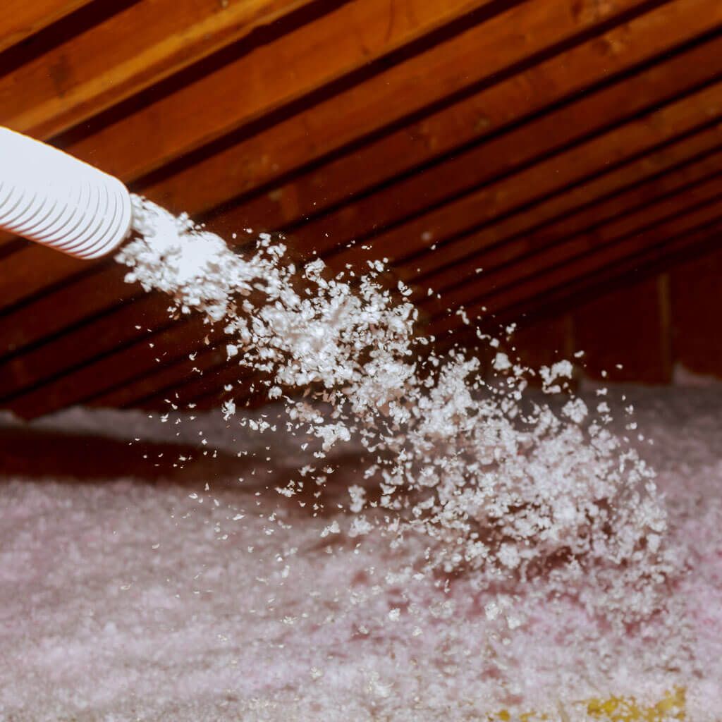 A white hose is spraying white foam into a room