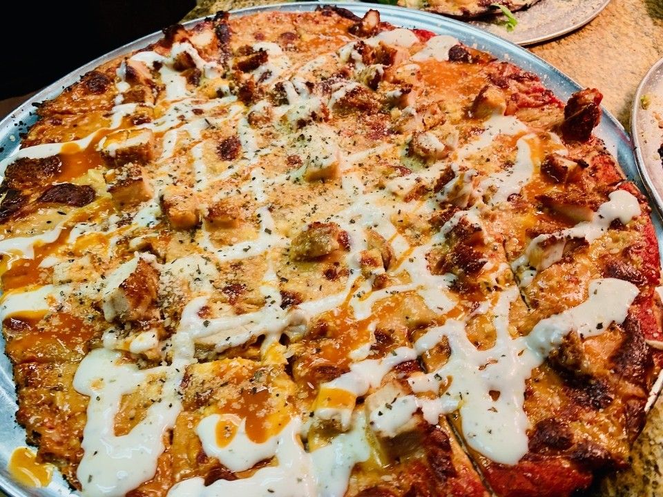 a pizza with a lot of toppings on it is on a pan .