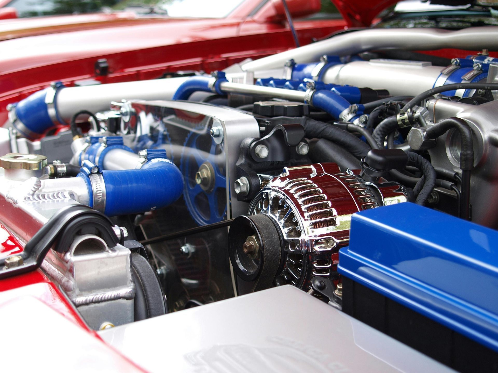 Close-up of a car engine bay with red bodywork and blue turbo components