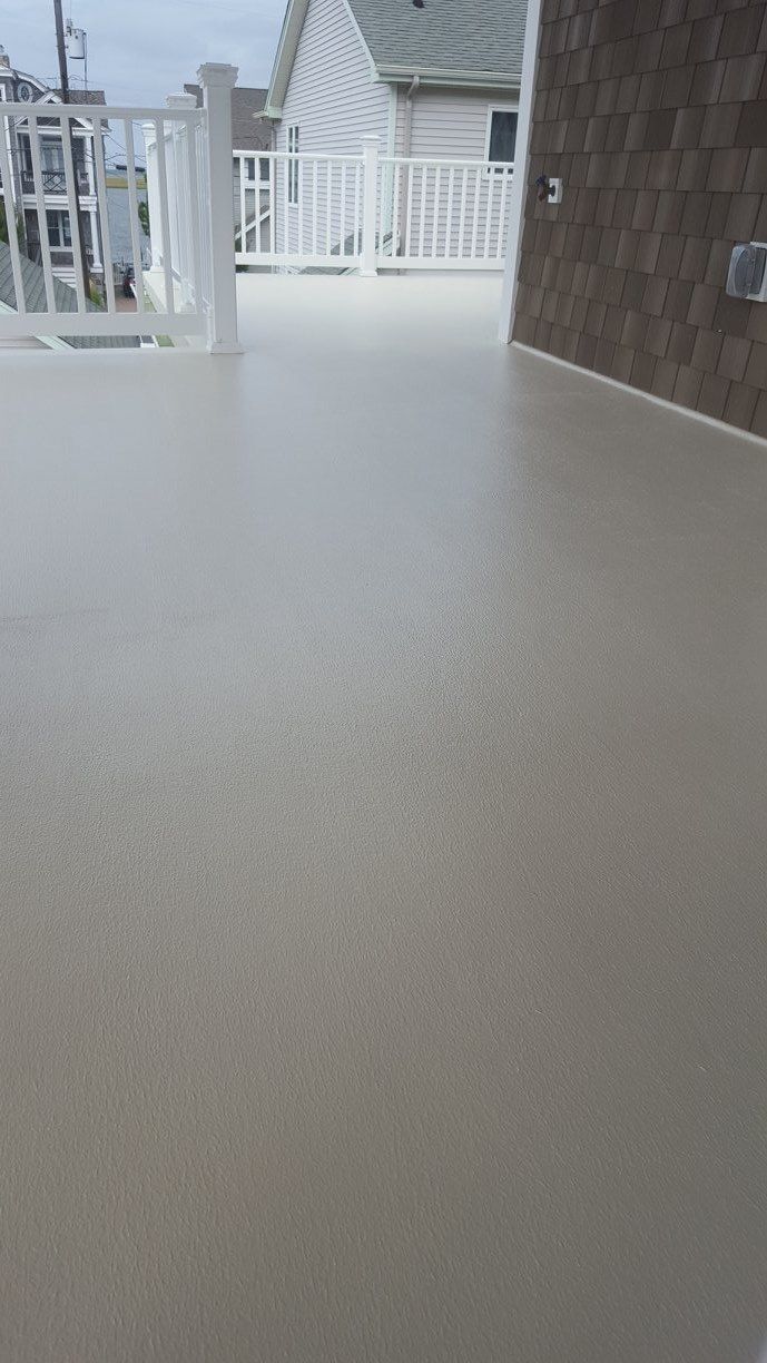A White Deck With a White Railing and a White Fence