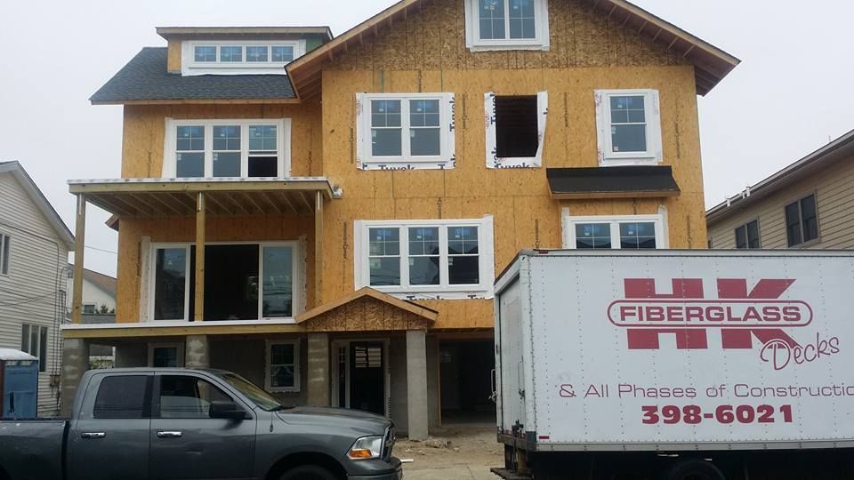 A fiberglass truck is parked in front of a house under construction