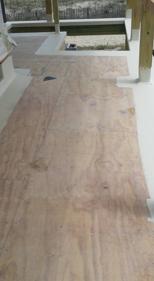 A large piece of plywood is sitting on top of a wooden floor