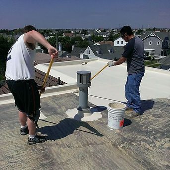 Two Men Are Painting the Roof of a Building