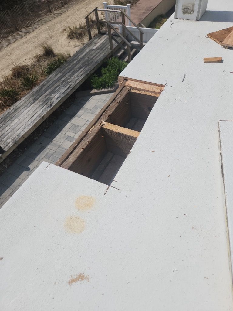 A white roof with a hole in it and a wooden bench in the background