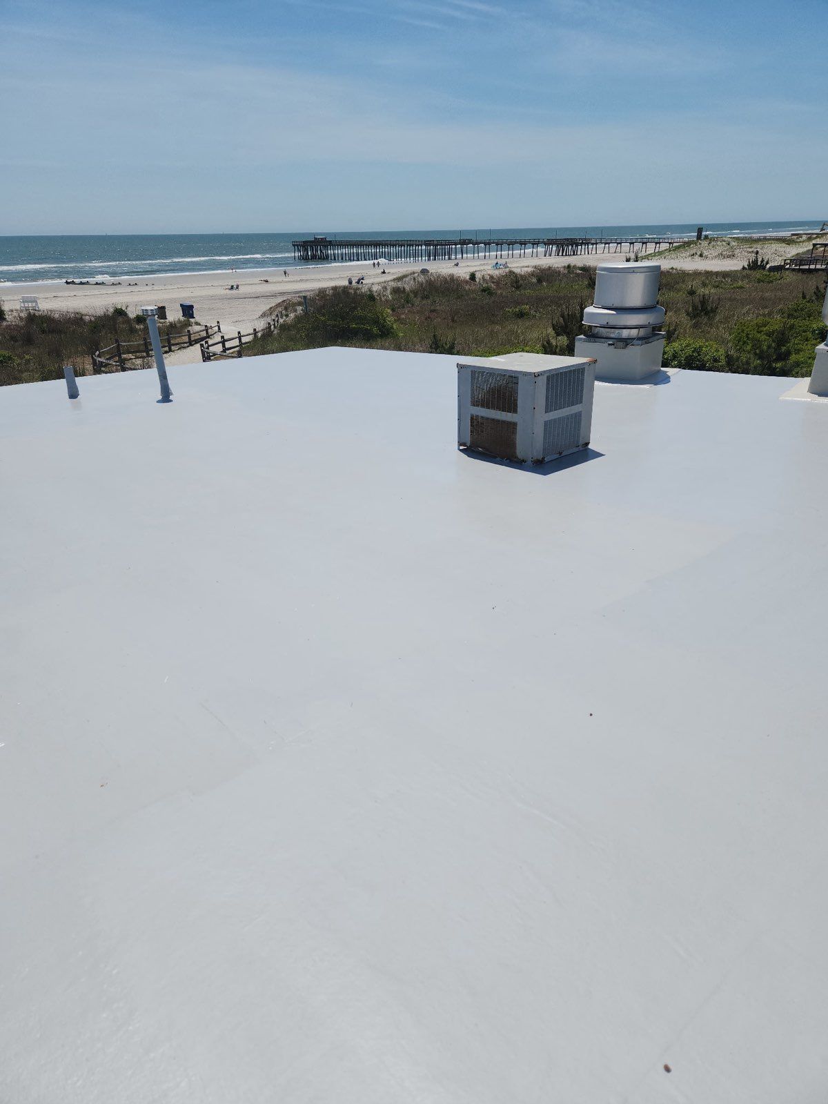 A white roof with a view of the ocean and a beach