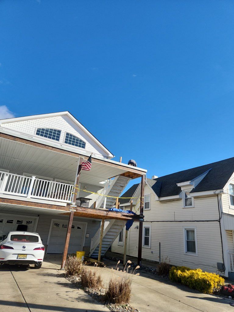 A white house with a car parked in front of it on a sunny day