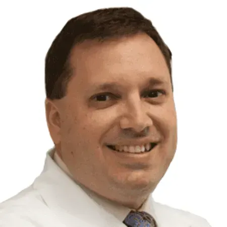 A smiling doctor in a lab coat with a stethoscope around his neck.