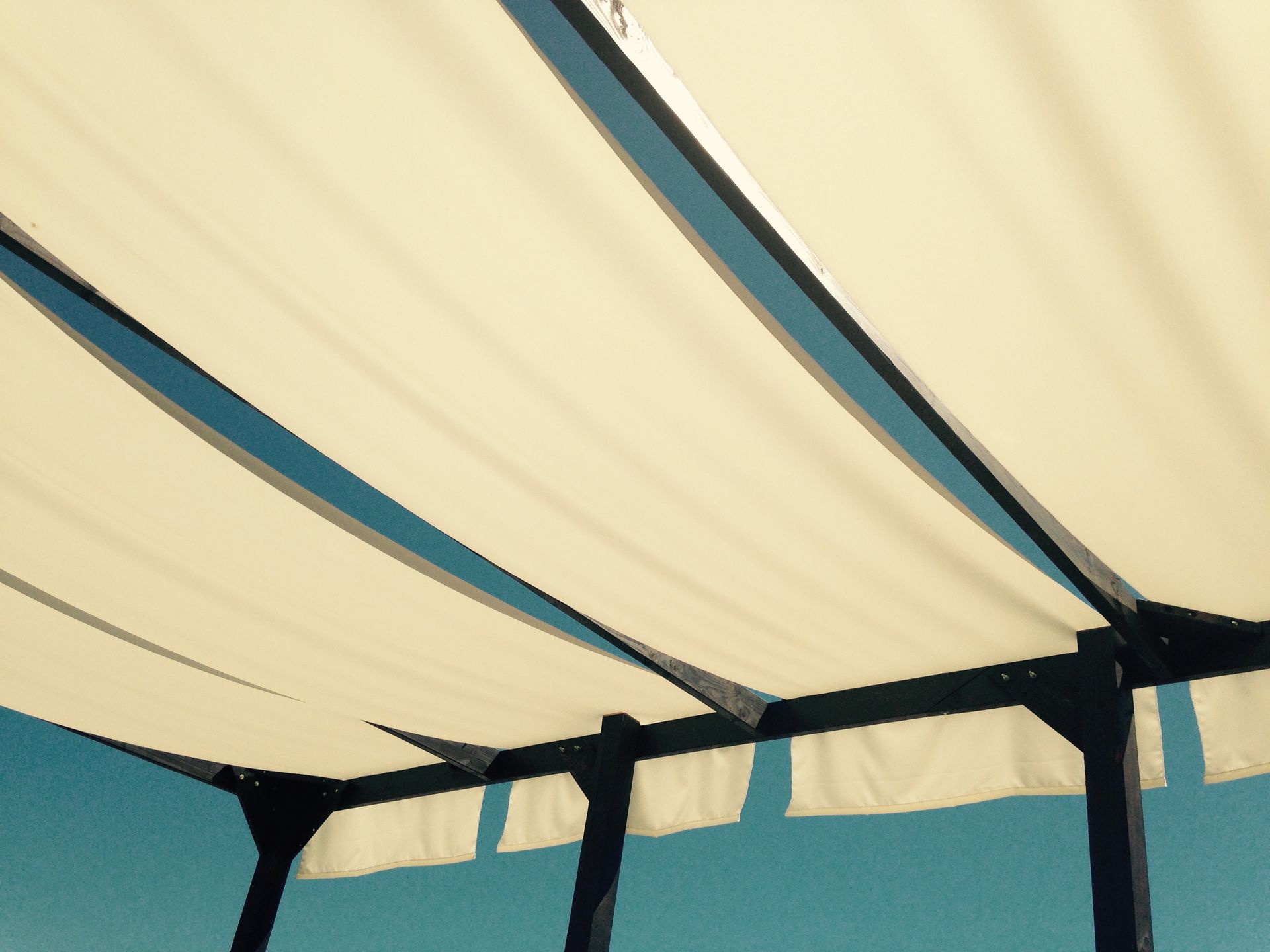 A white shade sail with a blue sky in the background | Cordova & Pasadena, MD | Shoreline Awning & Trim