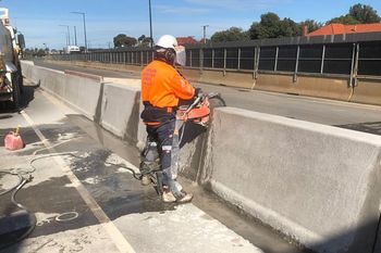 man cutting concrete barrier
