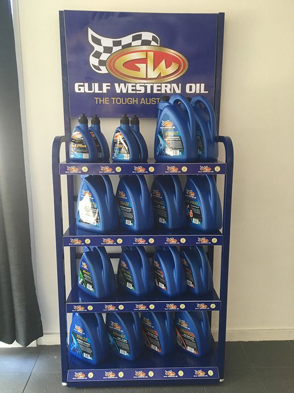 A Gulf Western Oil Display Filled with Blue Bottles — Fletcher's Truck and 4WD Repair Centre in Forster, NSW