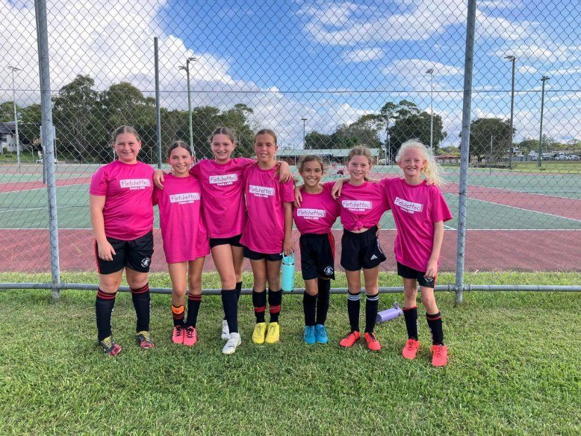A Group of Young Girls Wearing Pink Shirts Are Posing for A Picture — Fletcher's Truck and 4WD Repair Centre in Forster, NSW