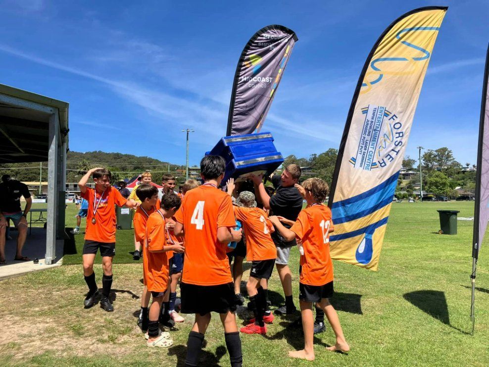 A Group of Young Boys Are Holding a Trophy in A Field  — Fletcher's Truck and 4WD Repair Centre in Forster, NSW