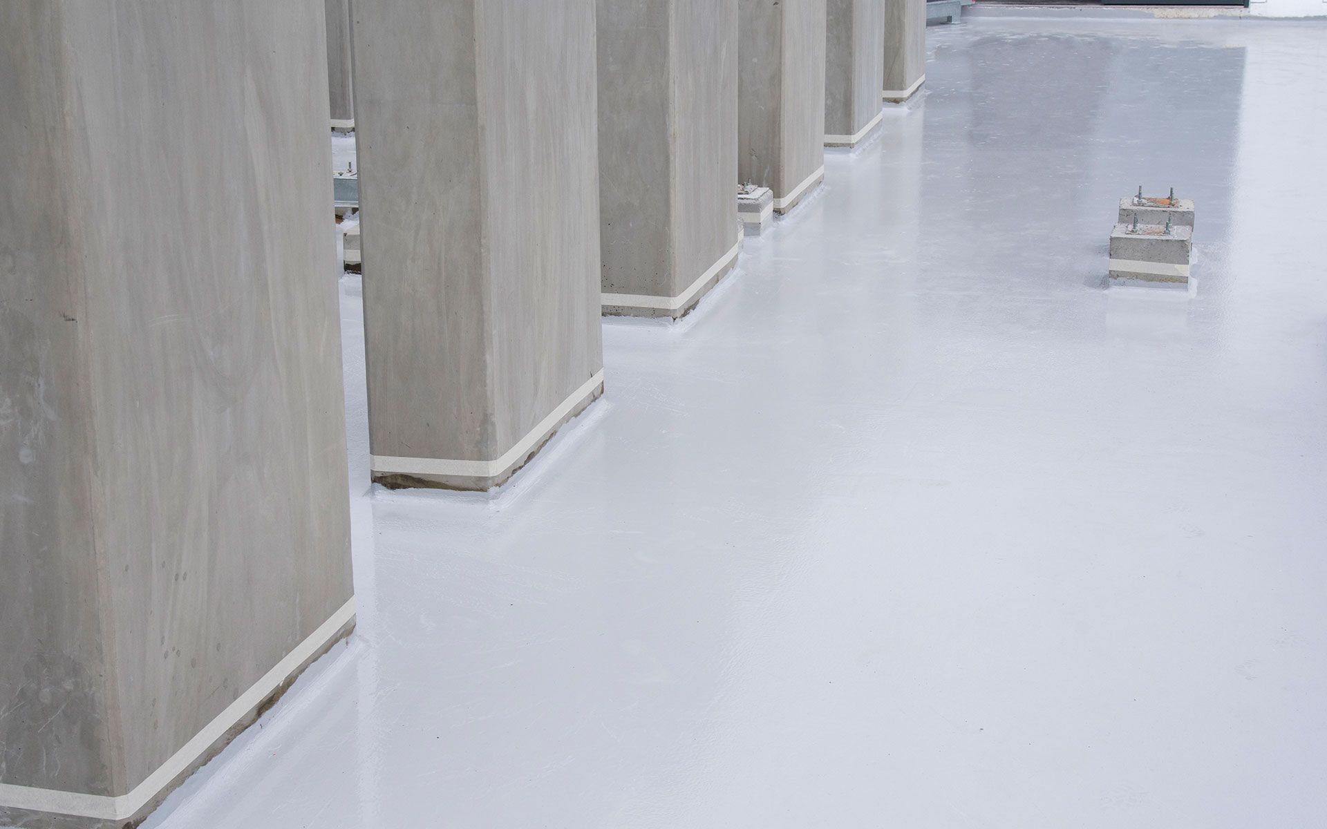 A row of concrete pillars sitting next to each other on a white floor.