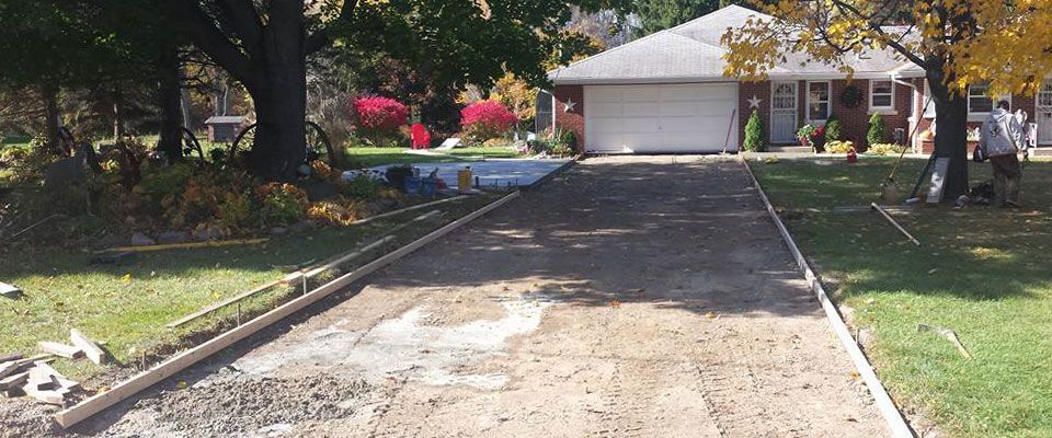 A driveway is being built in front of a house.