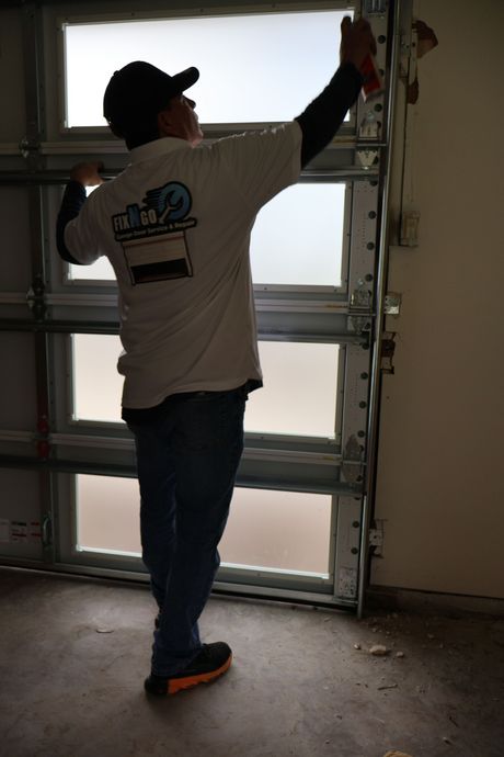a man on a ladder fixing the opener 