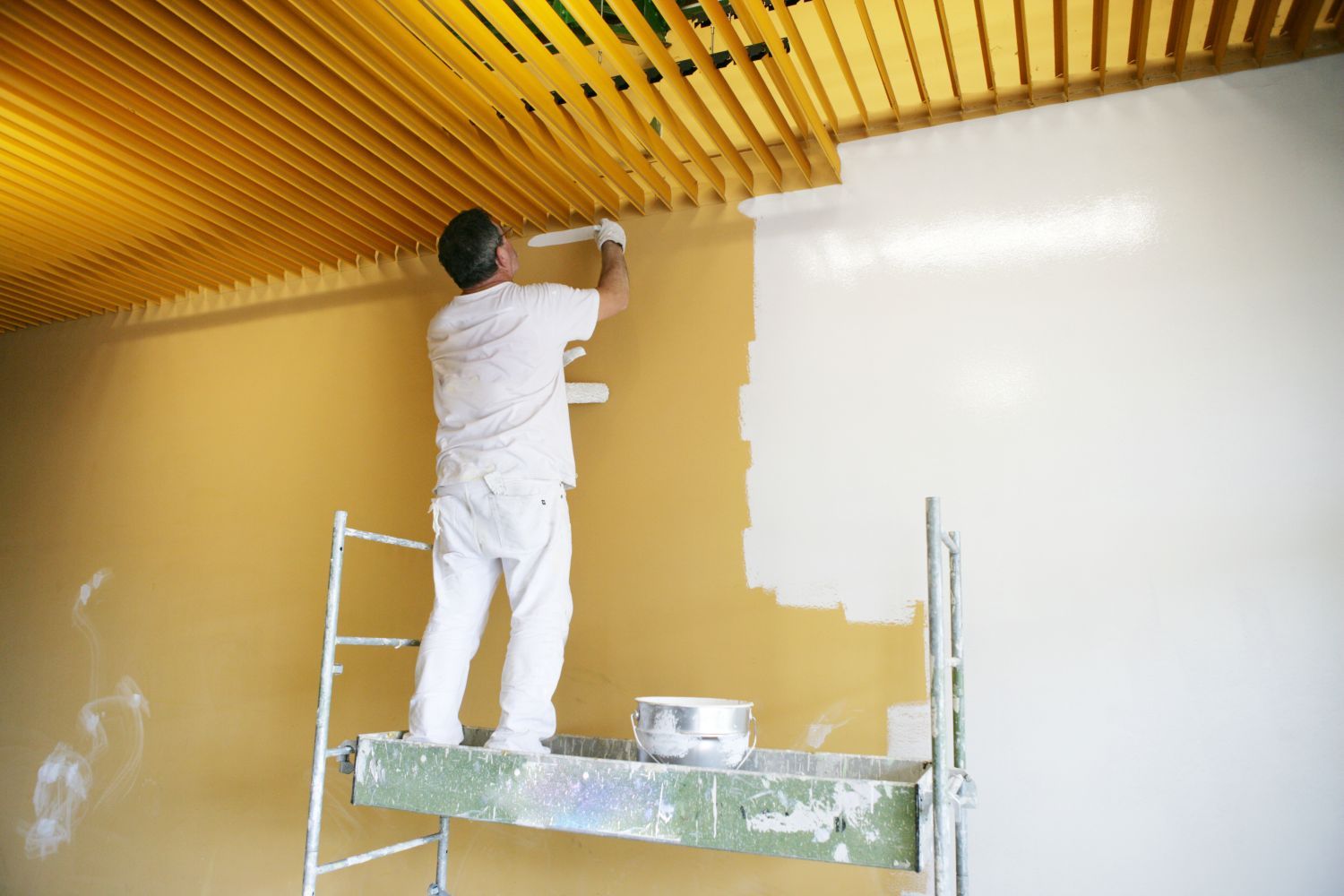 a man wearing a hard hat is plastering a wall