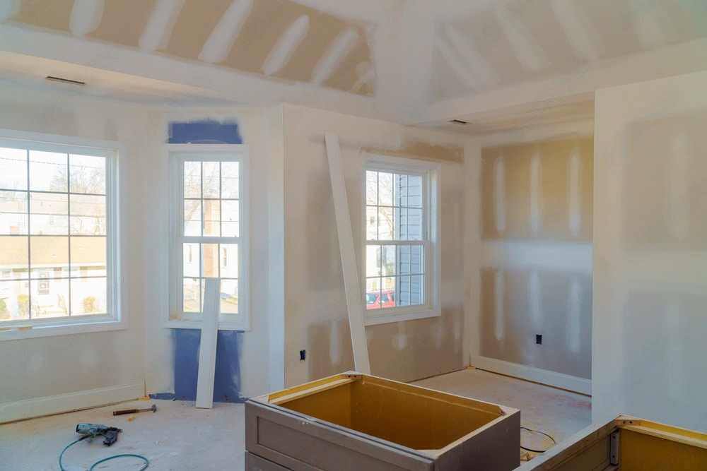 a room in a house under construction with drywall on the walls .