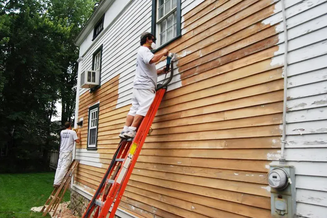 a man wearing a hard hat is plastering a wall