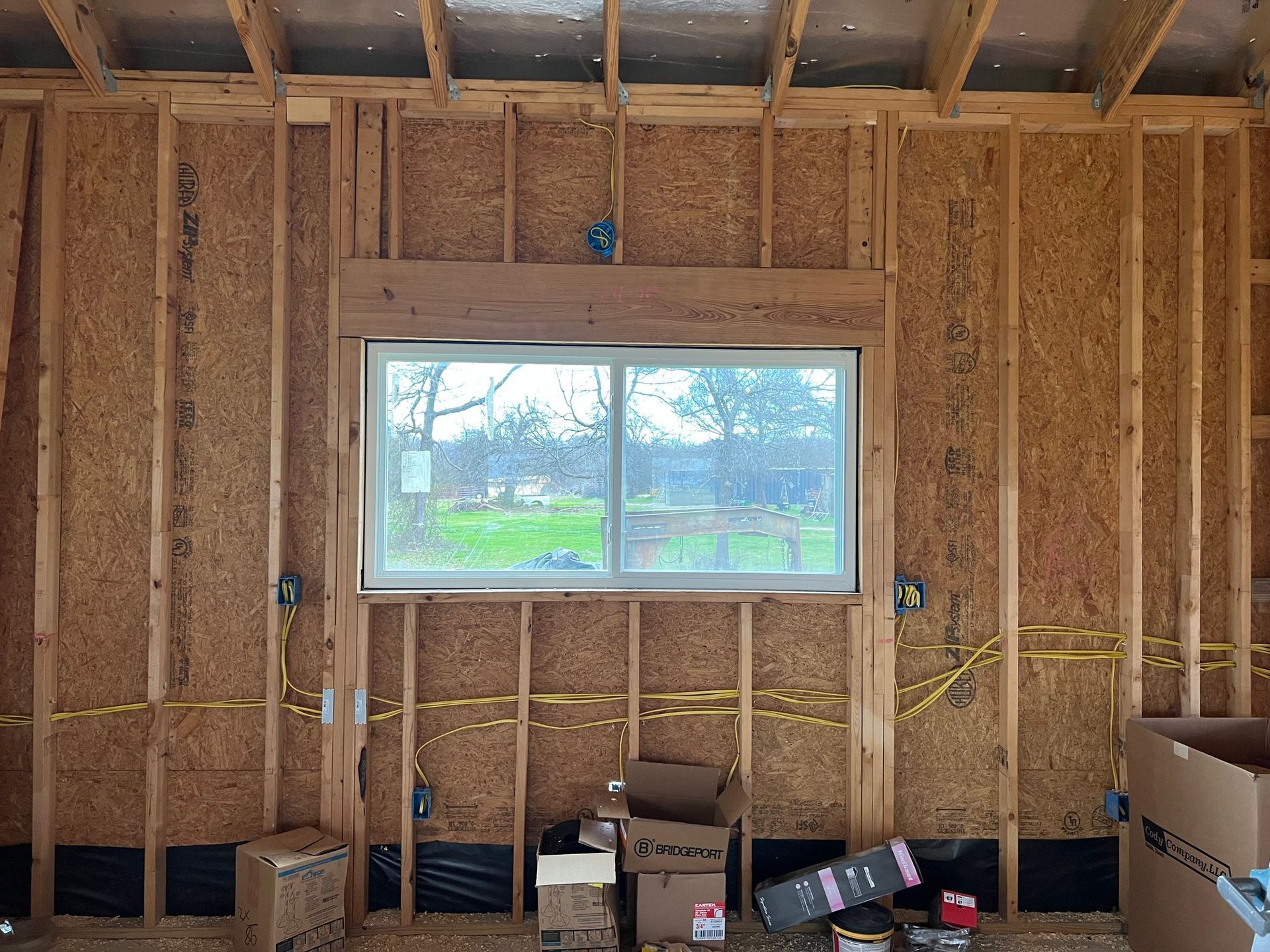 Electrician working on a circuit breaker panel with a screwdriver, indoors.