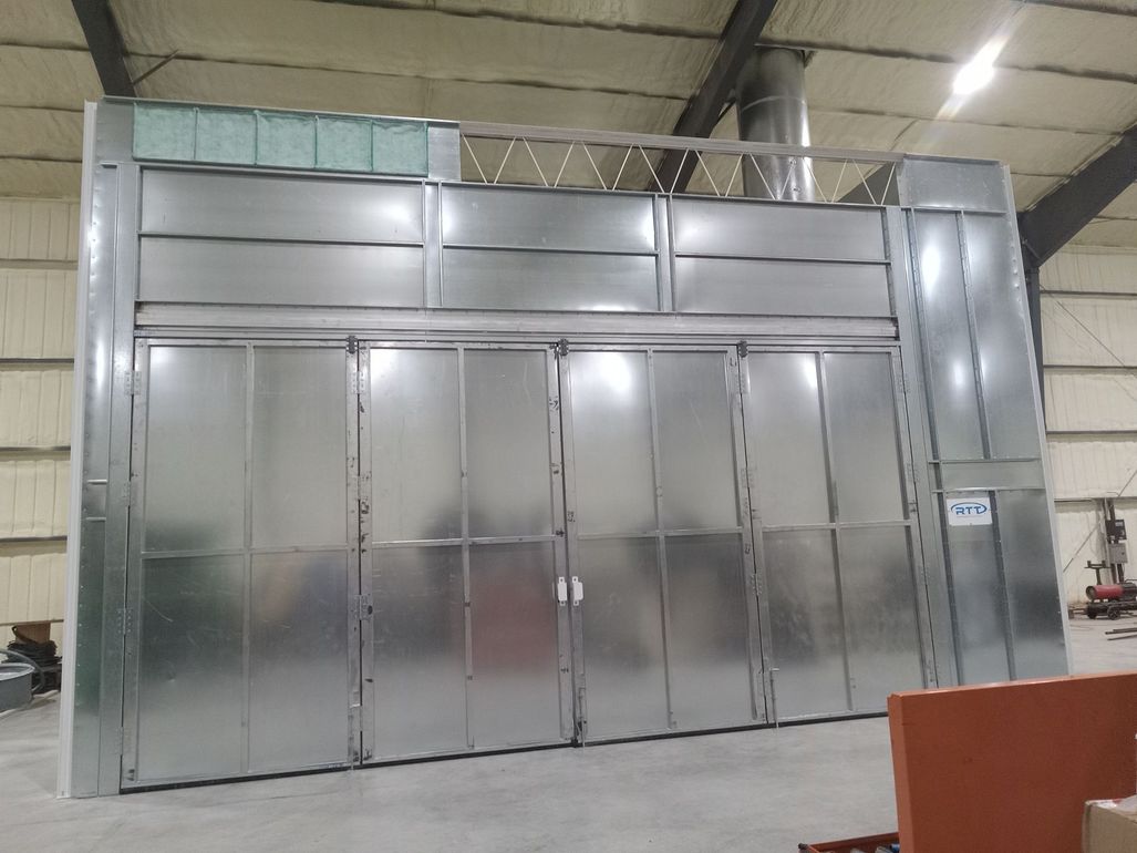 A car is wrapped in plastic in a paint booth.