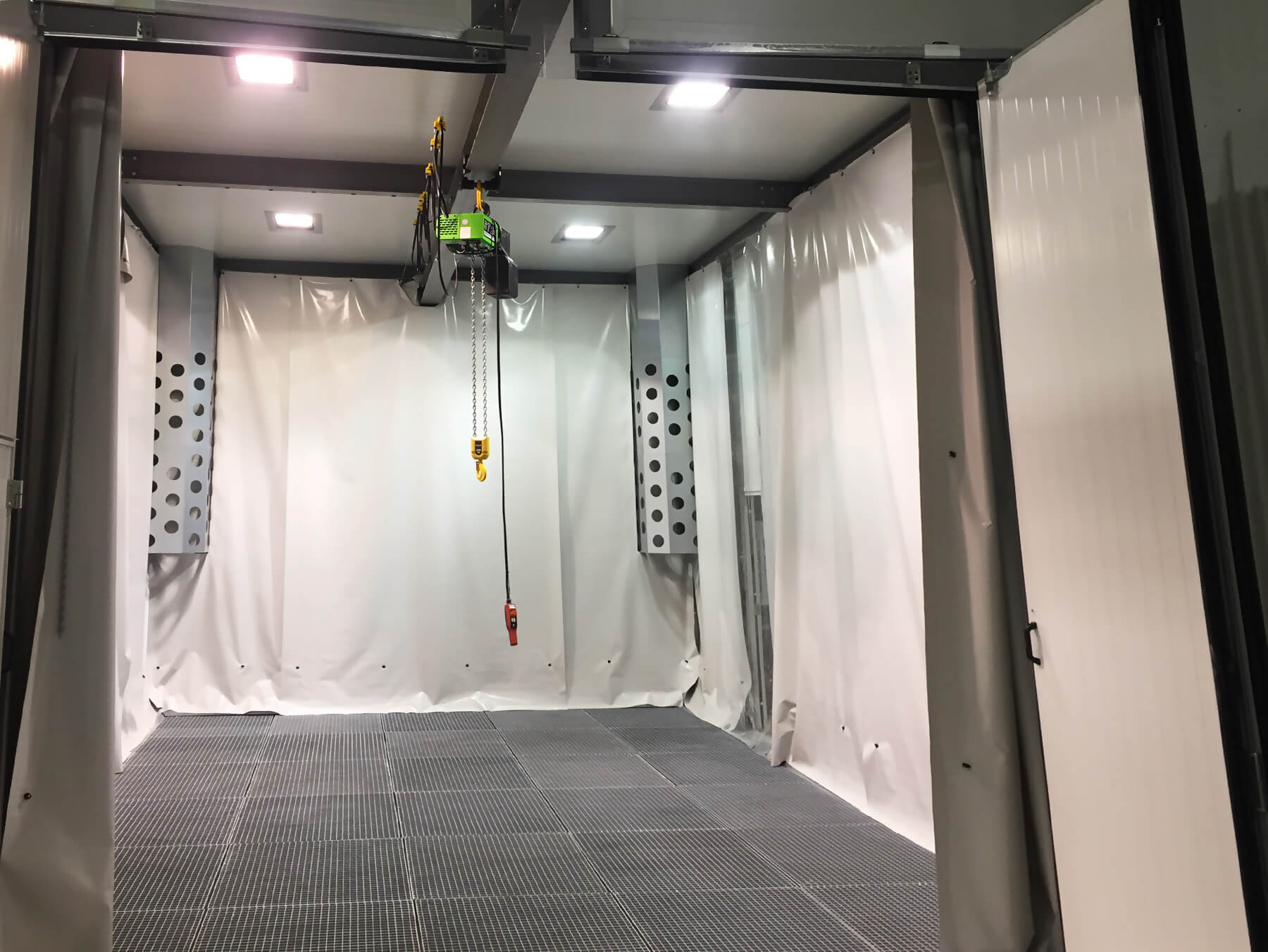 A large empty room with a crane hanging from the ceiling.