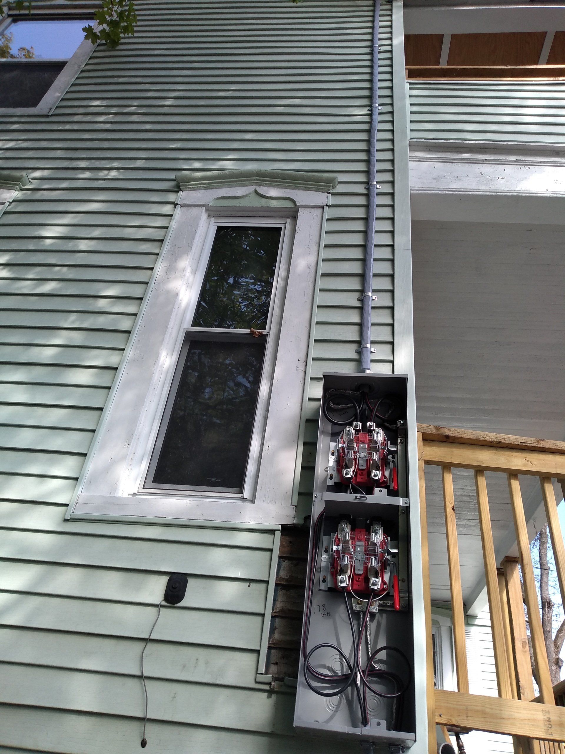 an electrical box mounted on the side of a house.