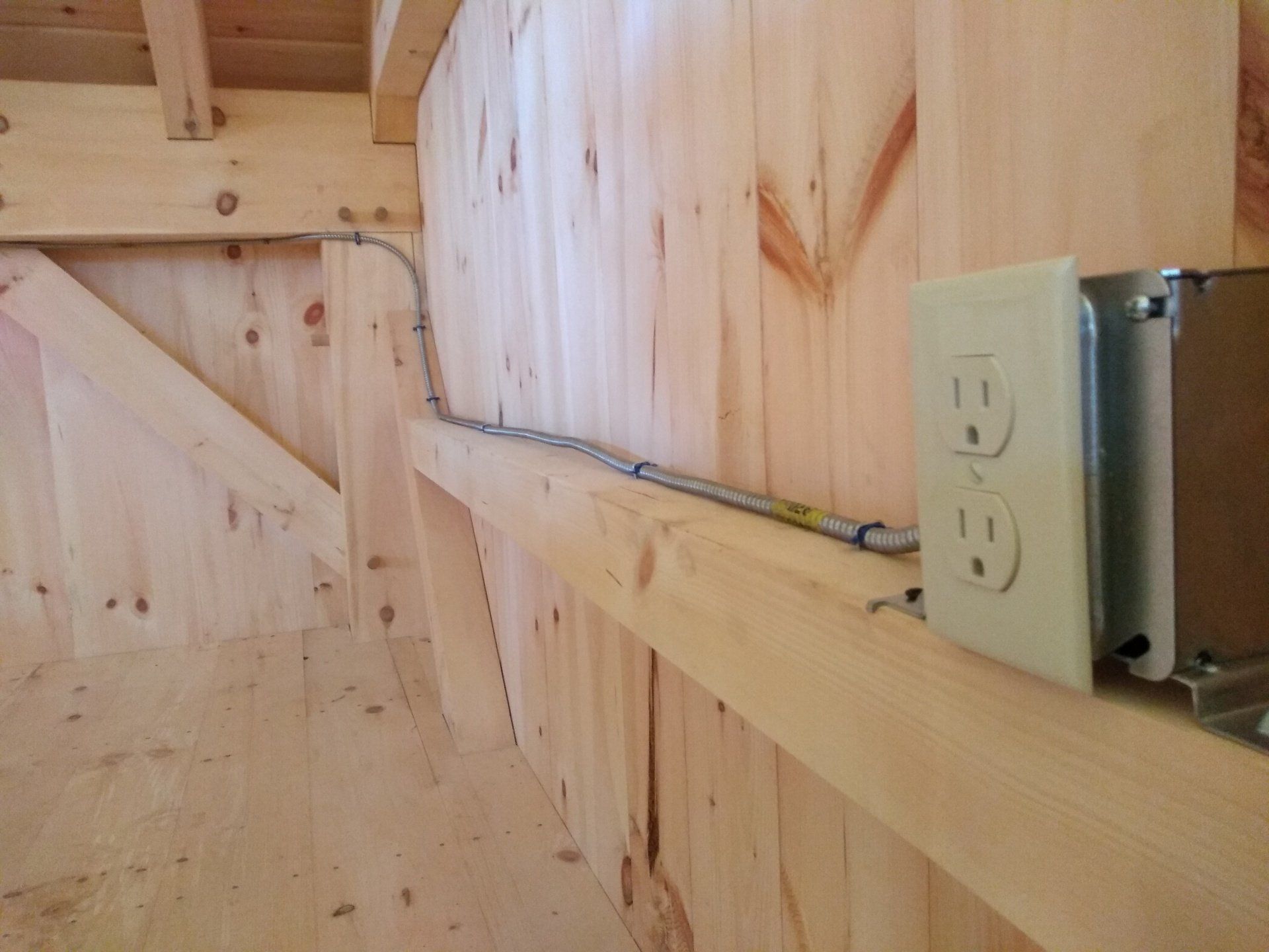 a wooden wall with two electrical outlets on it