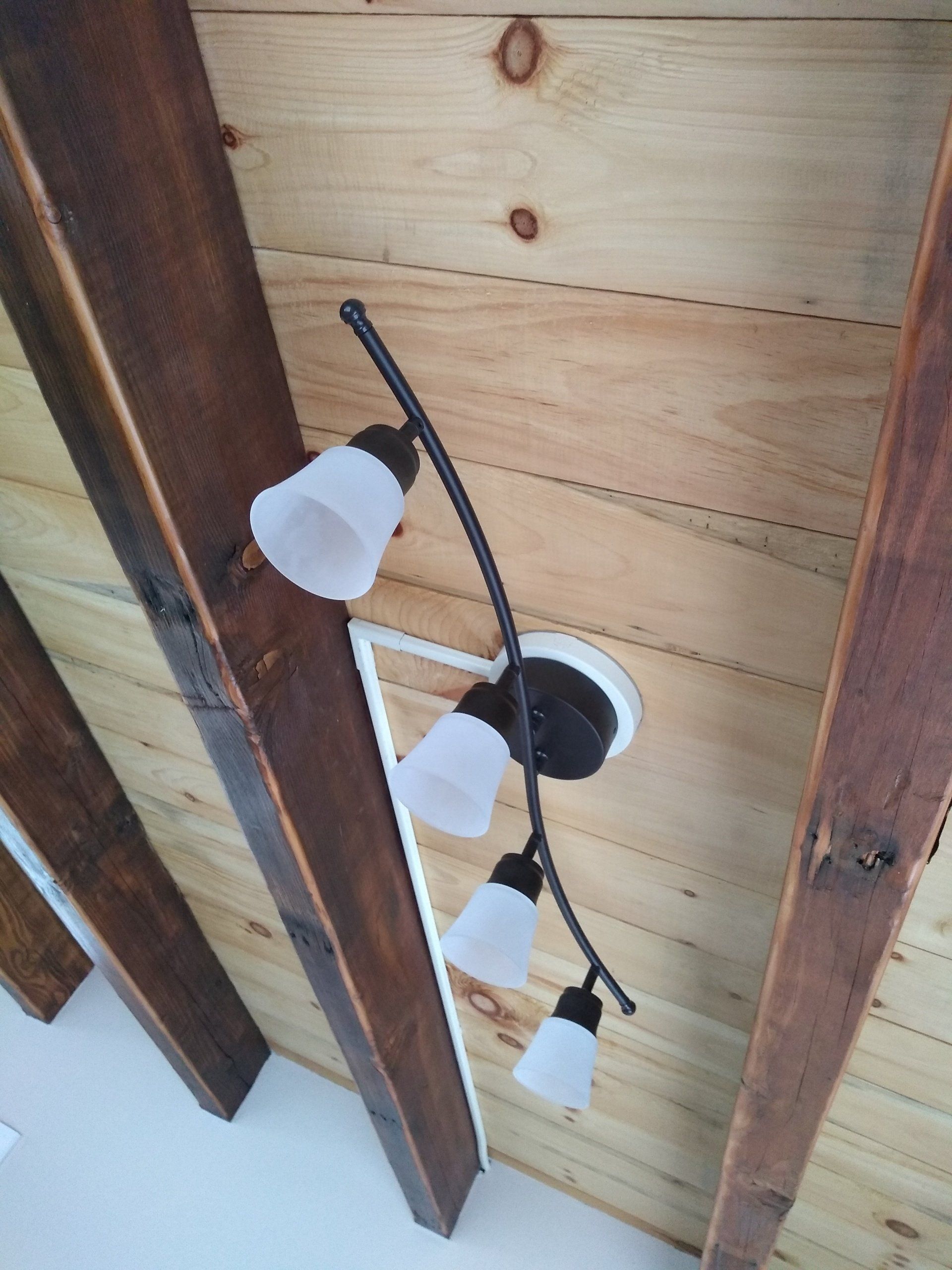 a light fixture hanging from a wooden ceiling