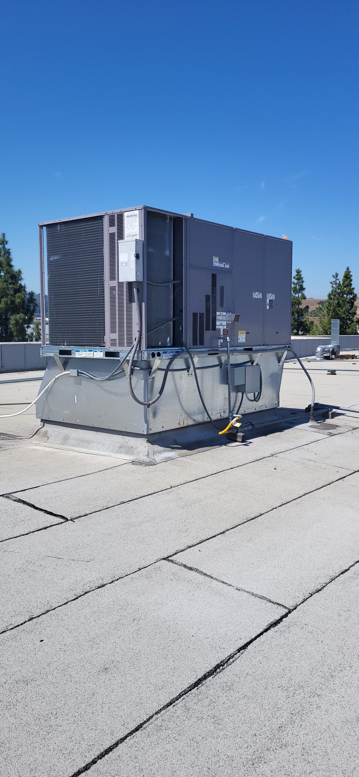 A large air conditioner is sitting on top of a roof.