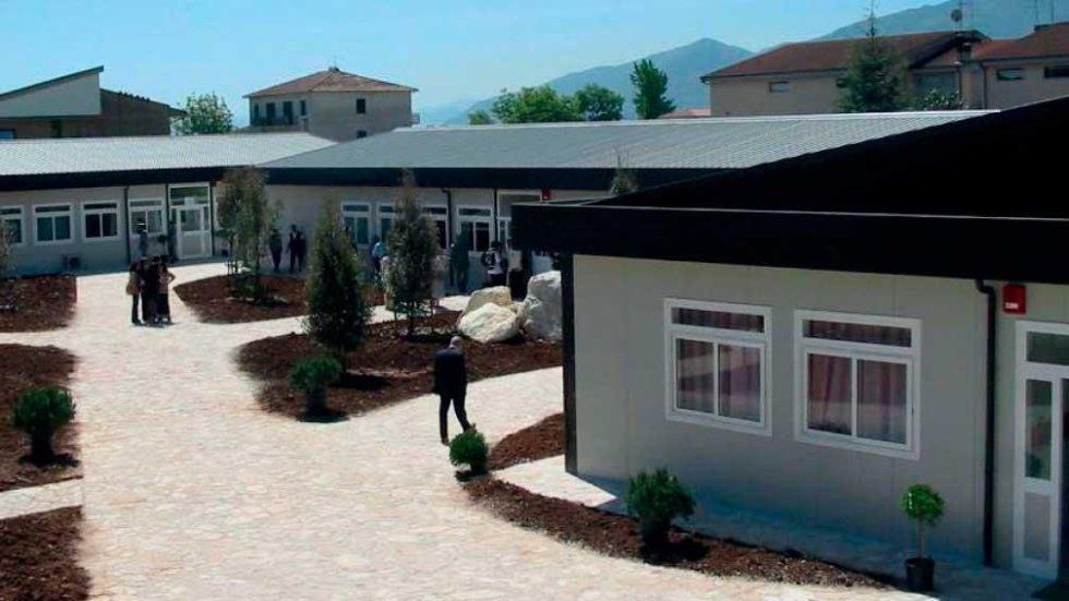 Un gruppo di persone si trova davanti a un edificio.