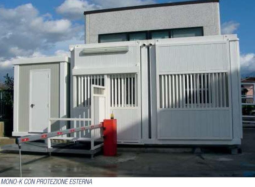 Un edificio bianco con una barriera rossa davanti