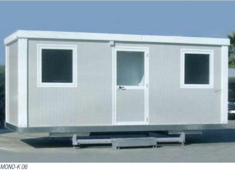 Un piccolo edificio bianco con due finestre e una porta