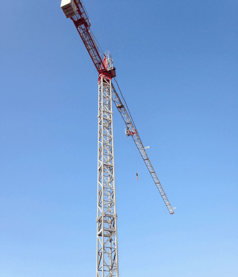 Una gru edile rossa e bianca contro un cielo blu